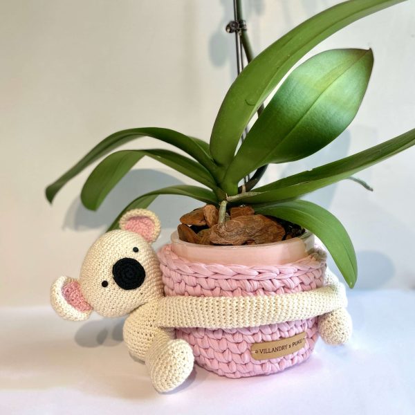 Delicada Orquídea en base de cerámica esmaltada de mango rojo envuelta en base de tejido reciclado realizado artesanalmente con un Peluche de Koala de Crochet artesanal tejido a mano.